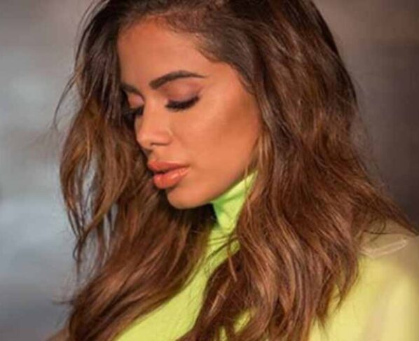 Anitta triste de camisa verde de gola alta